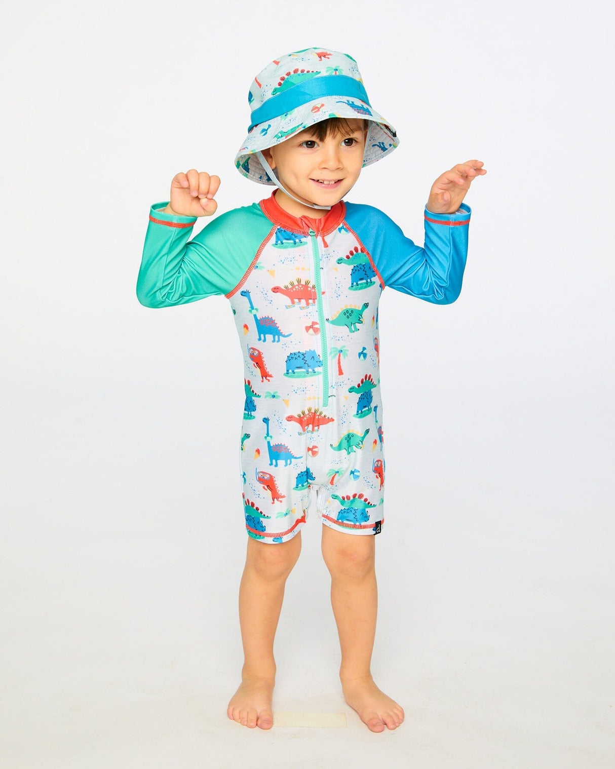 Toddler boy standing in grey dinosaur rashguard suit showing side view and sleeve length