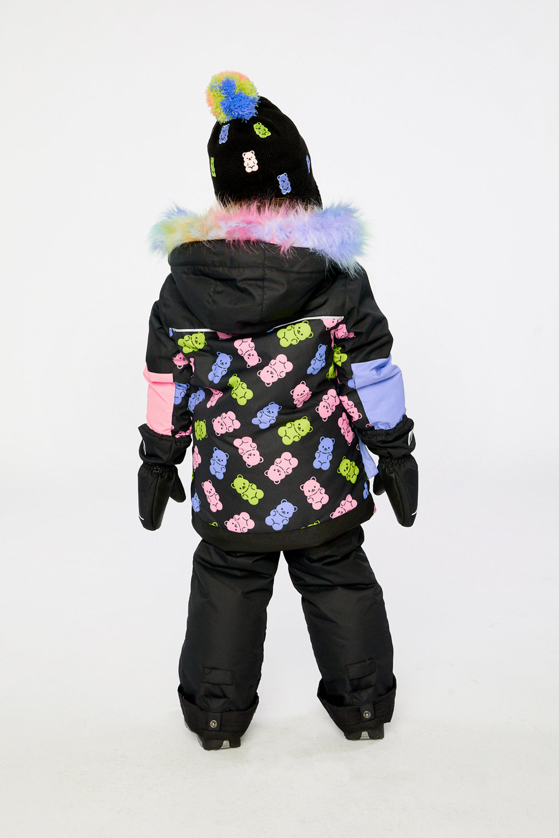 Back view of a child wearing the black gummy bear print PLAY snowsuit