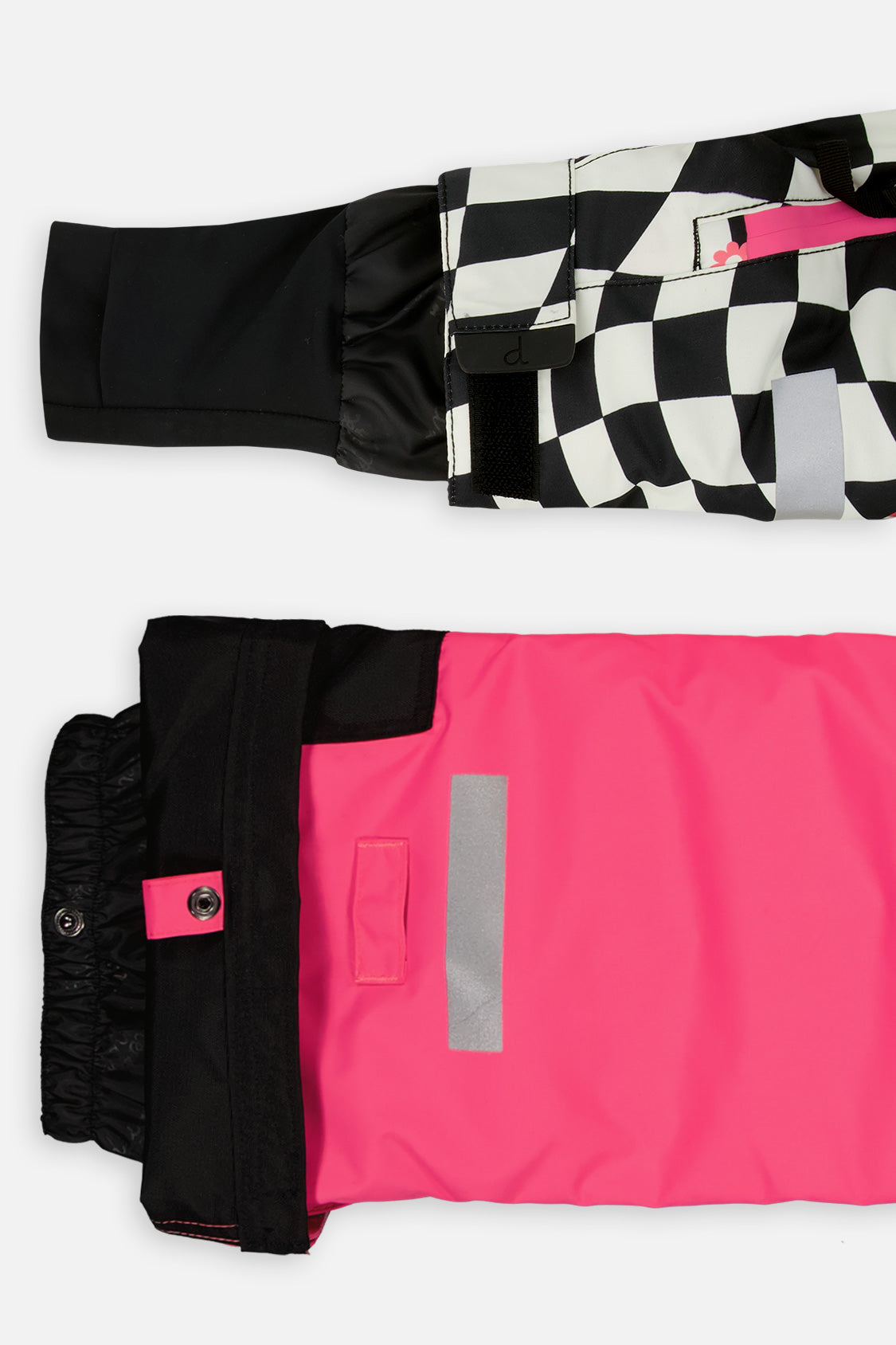 Close-up of the TEKNIK jacket cuff and the bright pink snow pant hem with snap tab