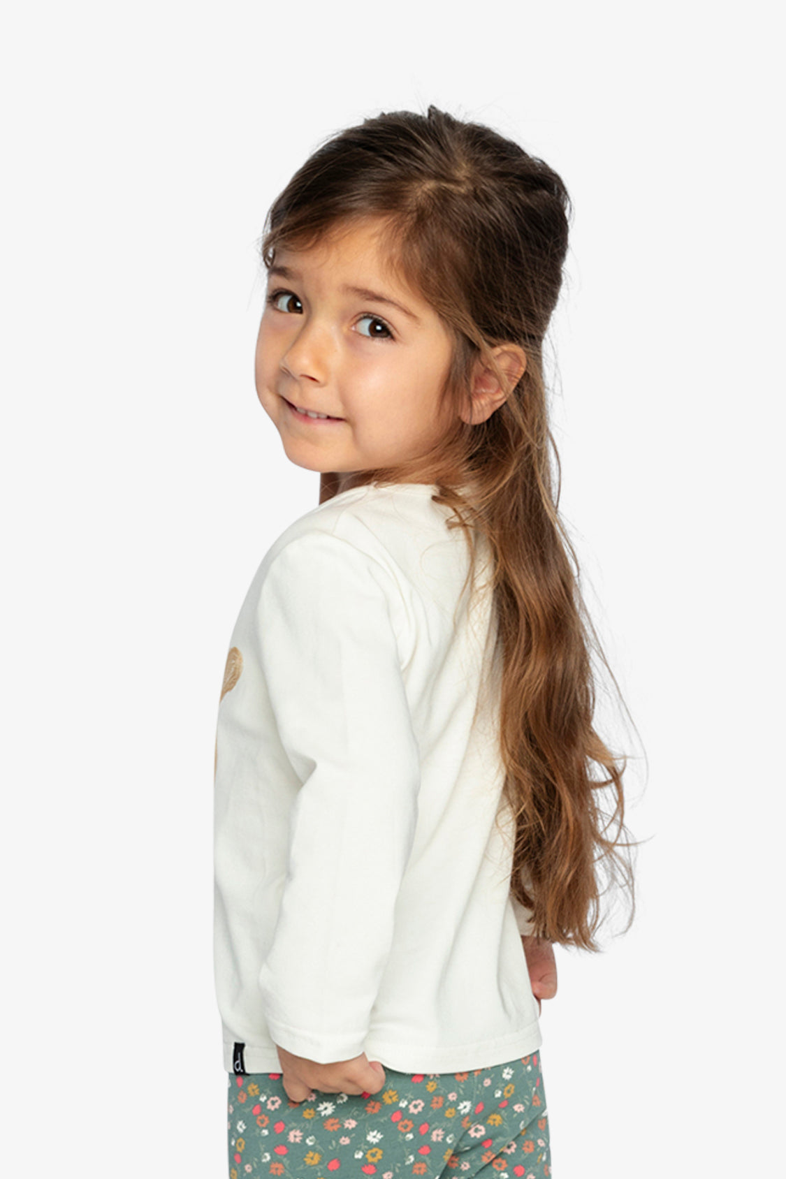 Child looking over the shoulder in the off-white long sleeve tee, back and side view