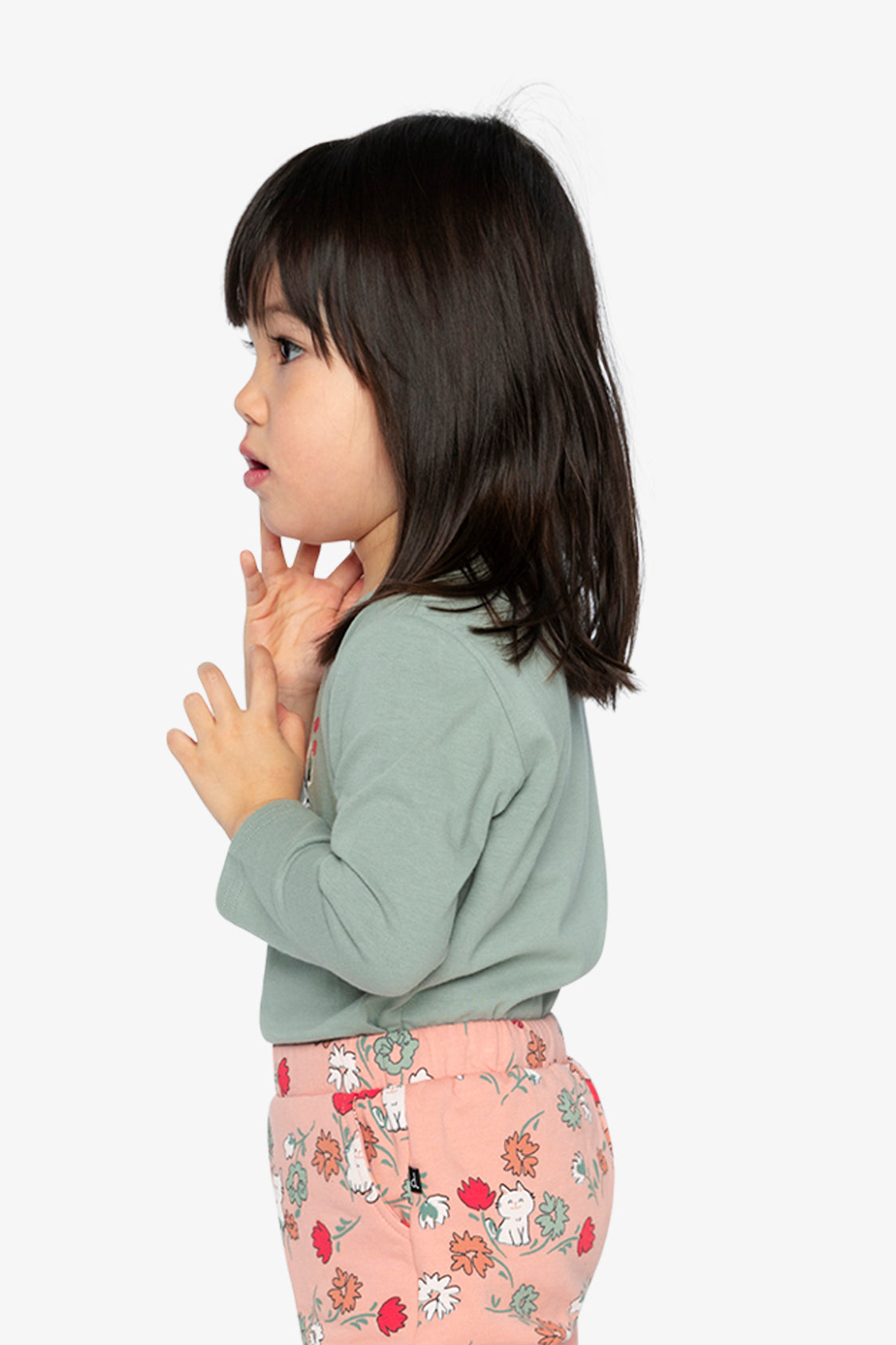 Child wearing the sage green long sleeve tee, side view