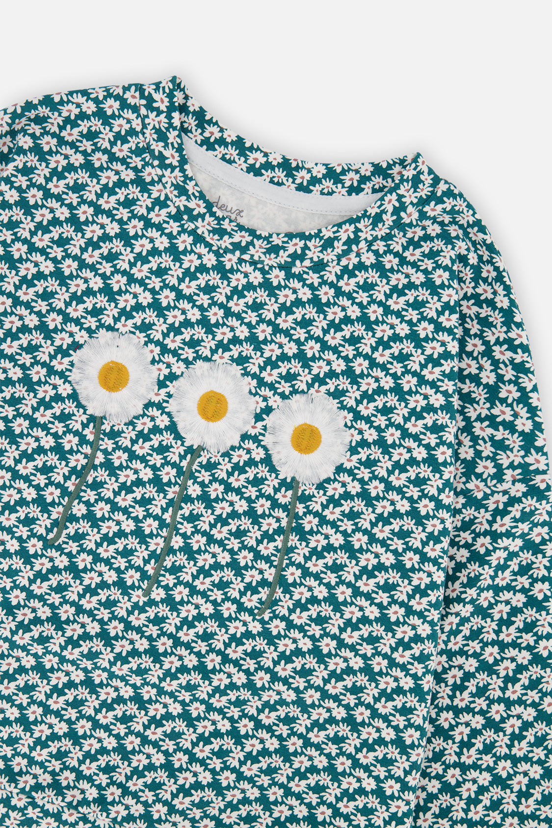Close-up of the three embroidered daisies on the green floral print long sleeve T-shirt