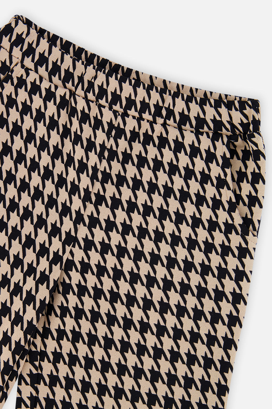 Close-up of the black and beige houndstooth pattern and elastic waist on flare pants