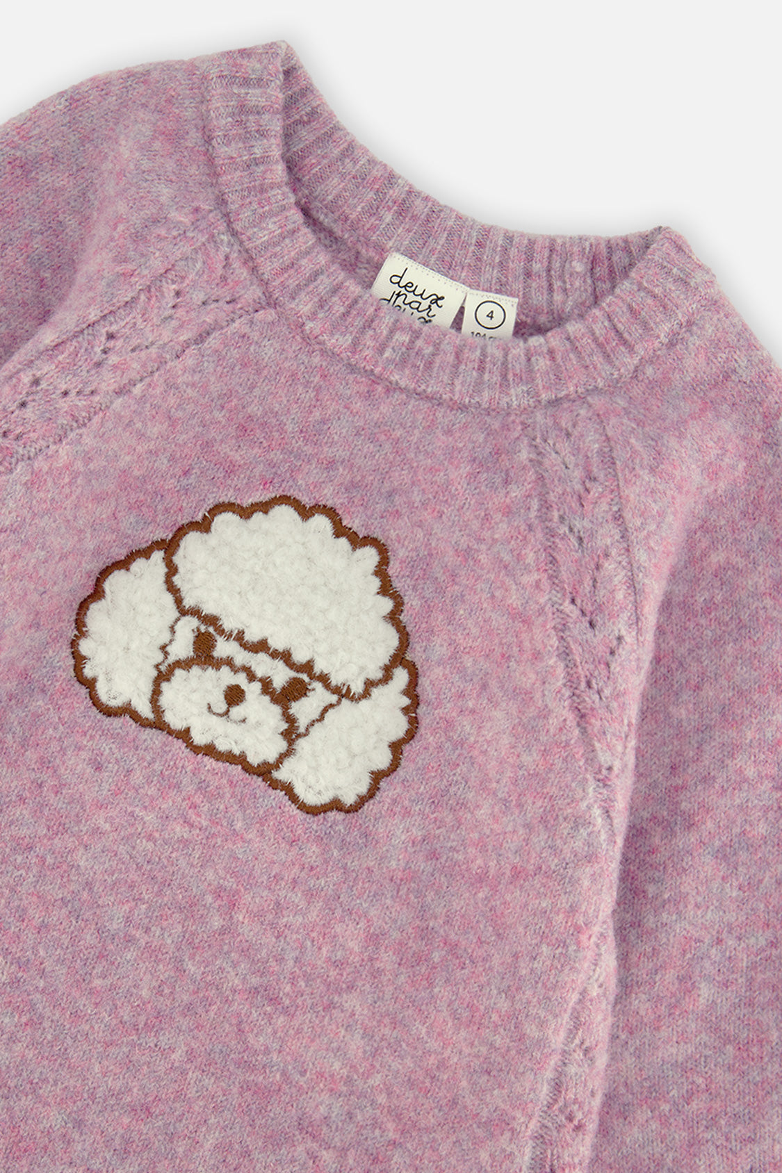 Close-up of the textured poodle appliqué and ribbed neckline on the lavender dress