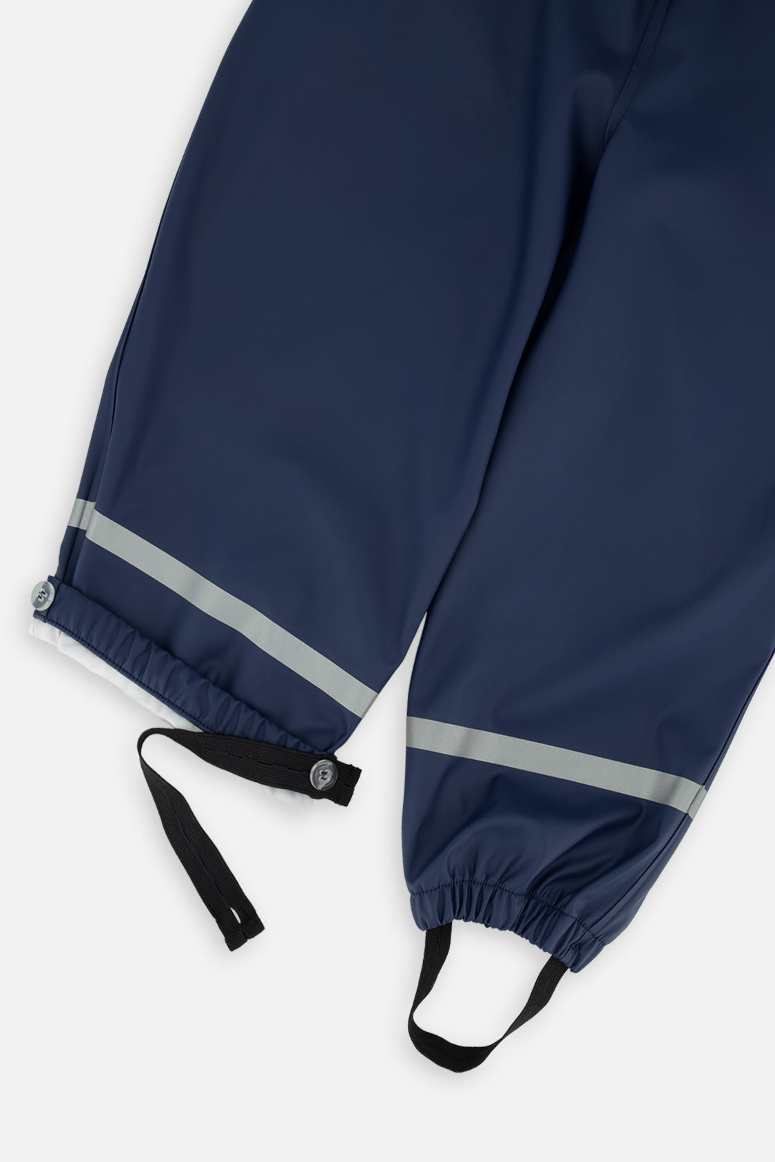 Close-up of the dark blue rain overalls ankles with reflective bands, elastic cuffs and foot straps