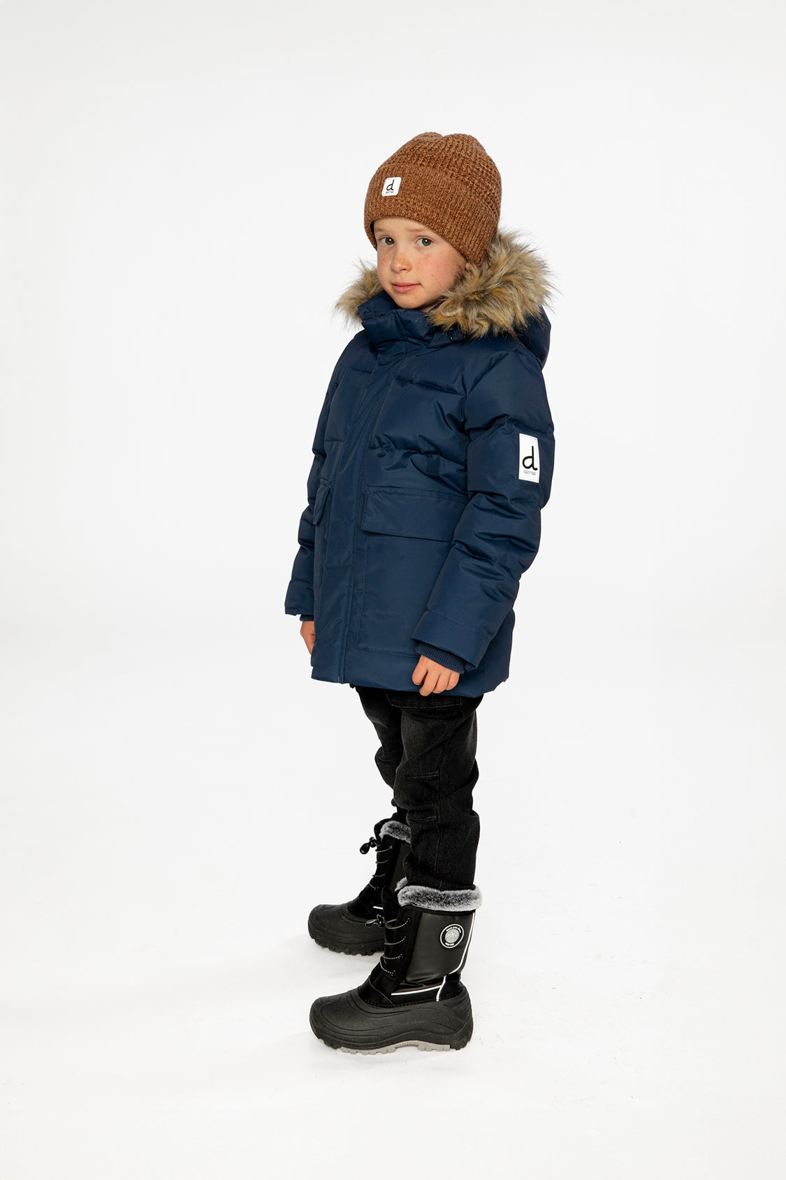 Child wearing the Deux par Deux dark blue winter jacket with faux-fur hood, view 3
