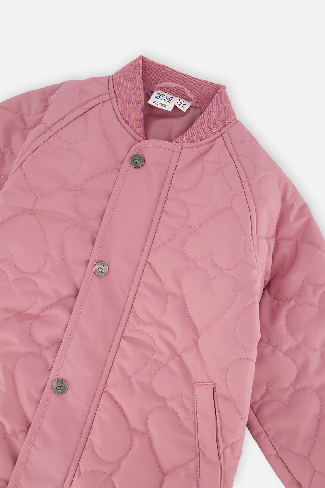 Close-up of the ribbed collar, snap front and heart-shaped quilting on the mauve pink jacket