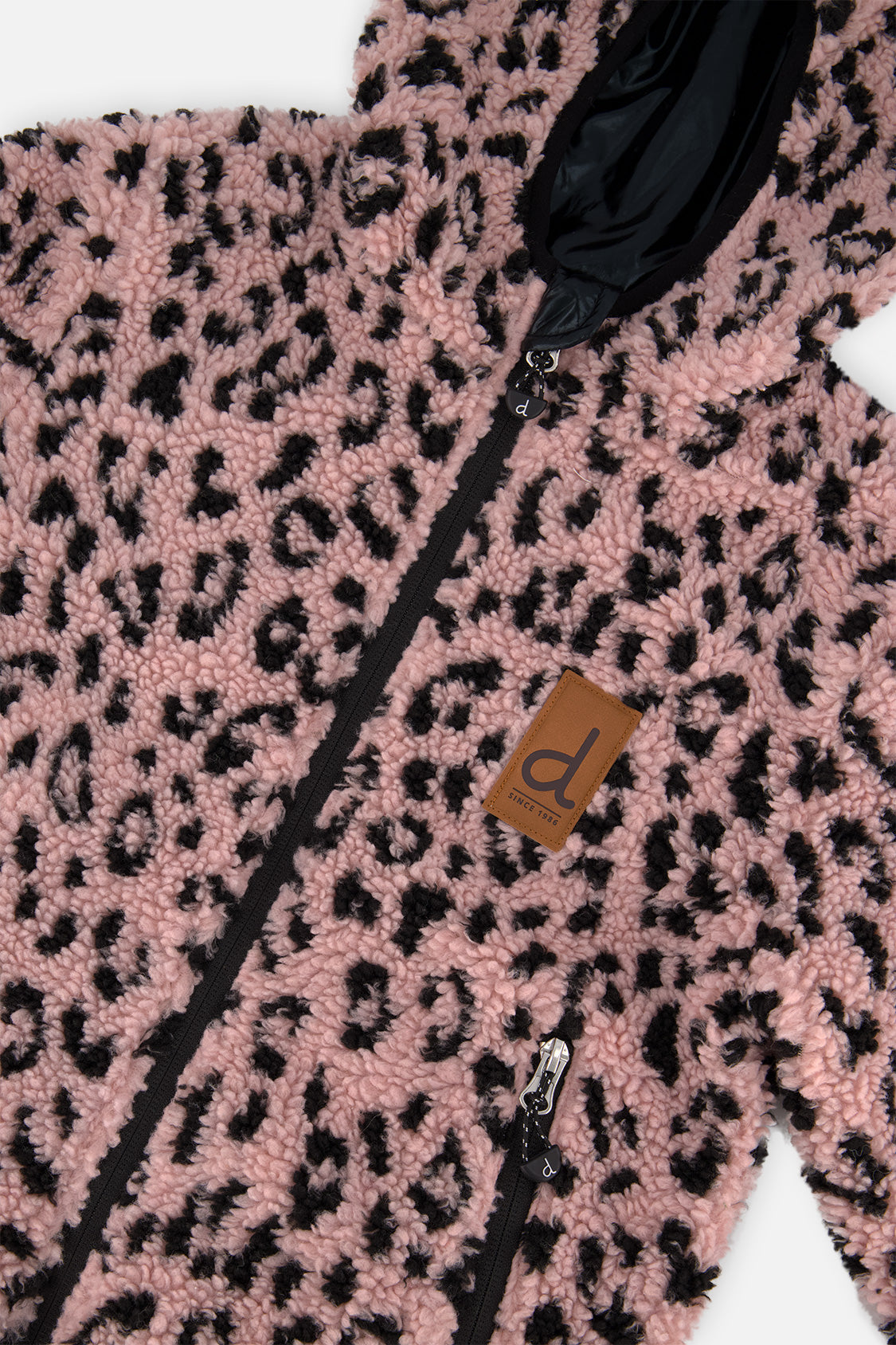 Close-up of the pink sherpa with black leopard-style spots and the front zip on the reversible jacket