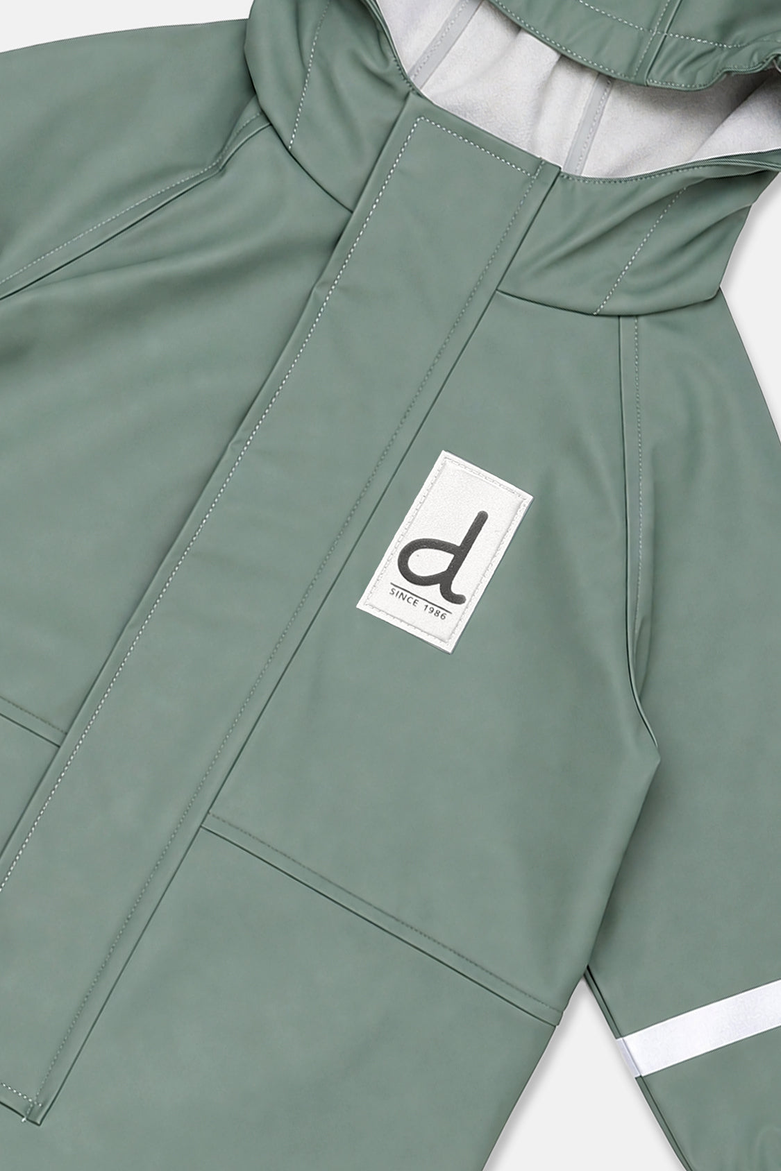 Close-up of the sage green zipper placket, d logo patch and reflective sleeve band
