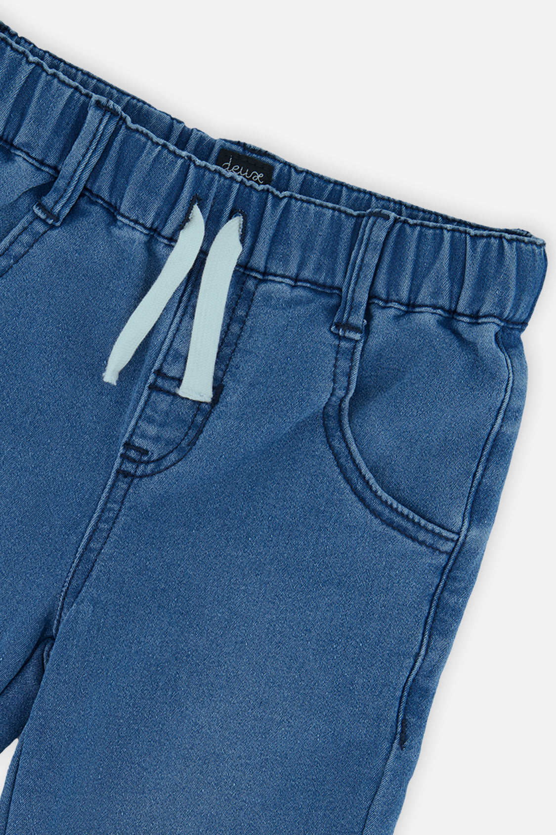 Close-up of the elastic waist, light blue drawcord and front pocket on denim-look French terry joggers