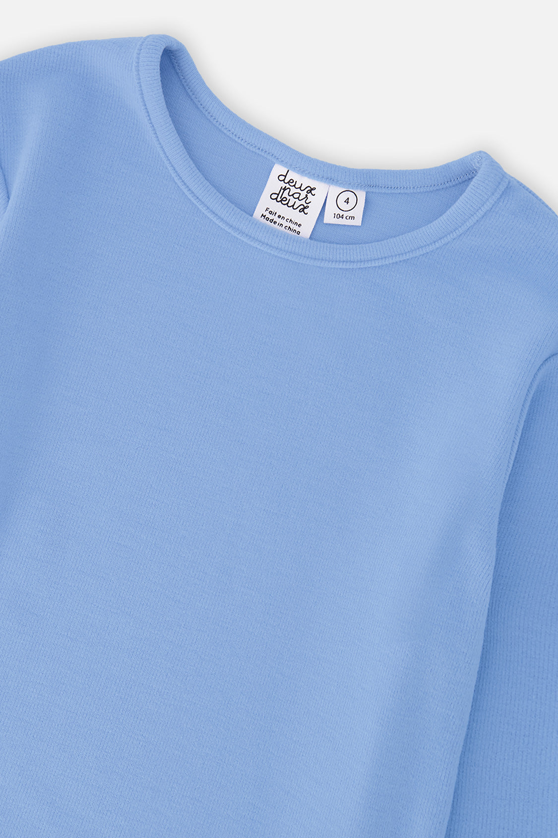 Close-up of the crew neckline and rib knit on the pale blue top