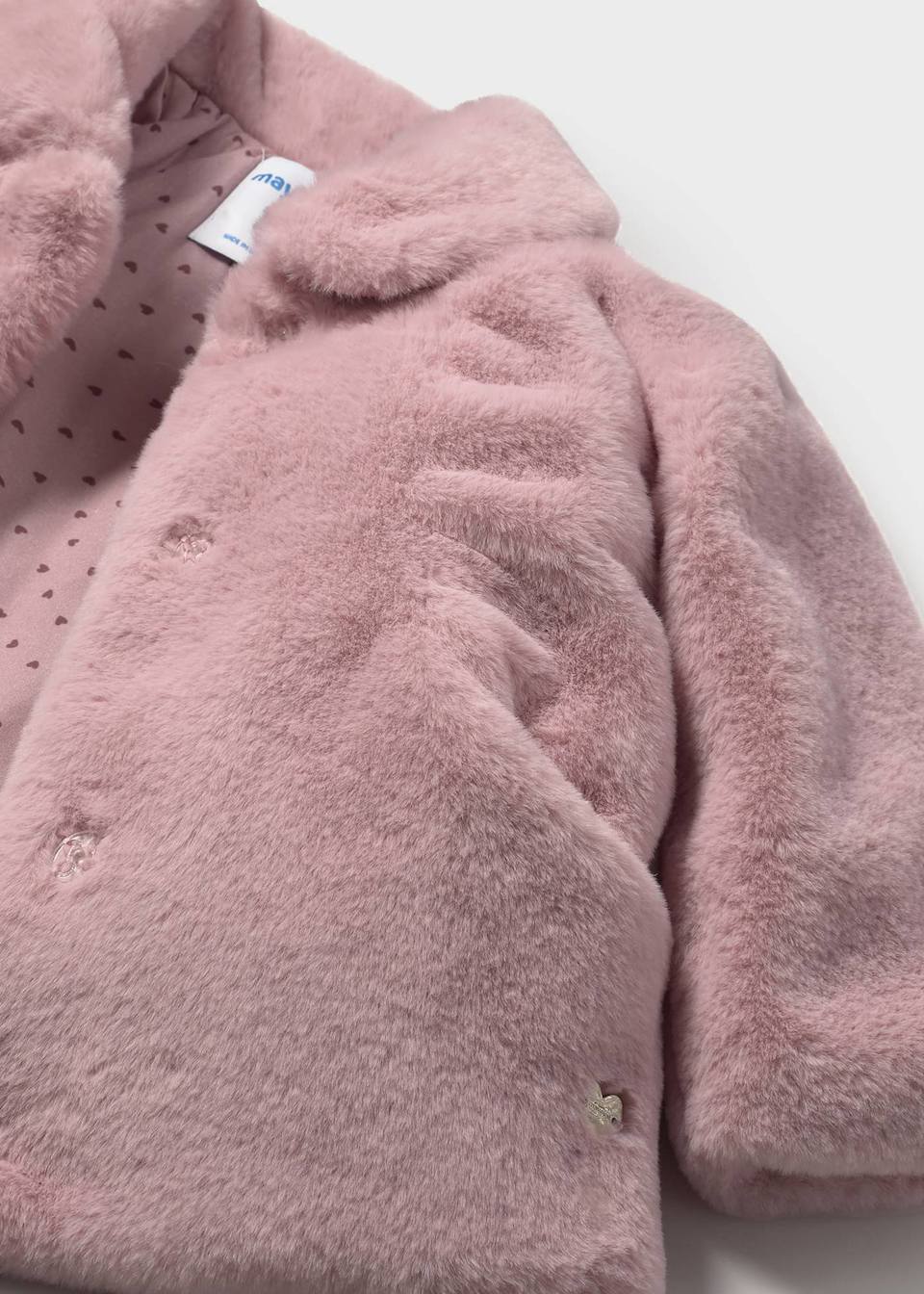 Closeup of plush faux fur and snap closure on girls winter coat.