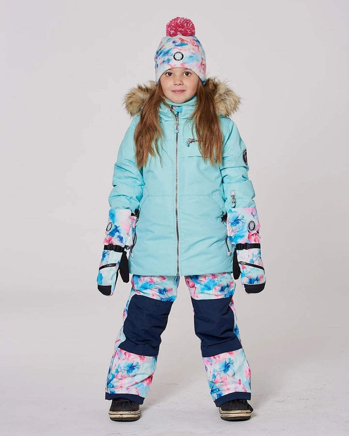 Model wearing Blue Flower jacket and snow pants, detachable hood and snow skirt.