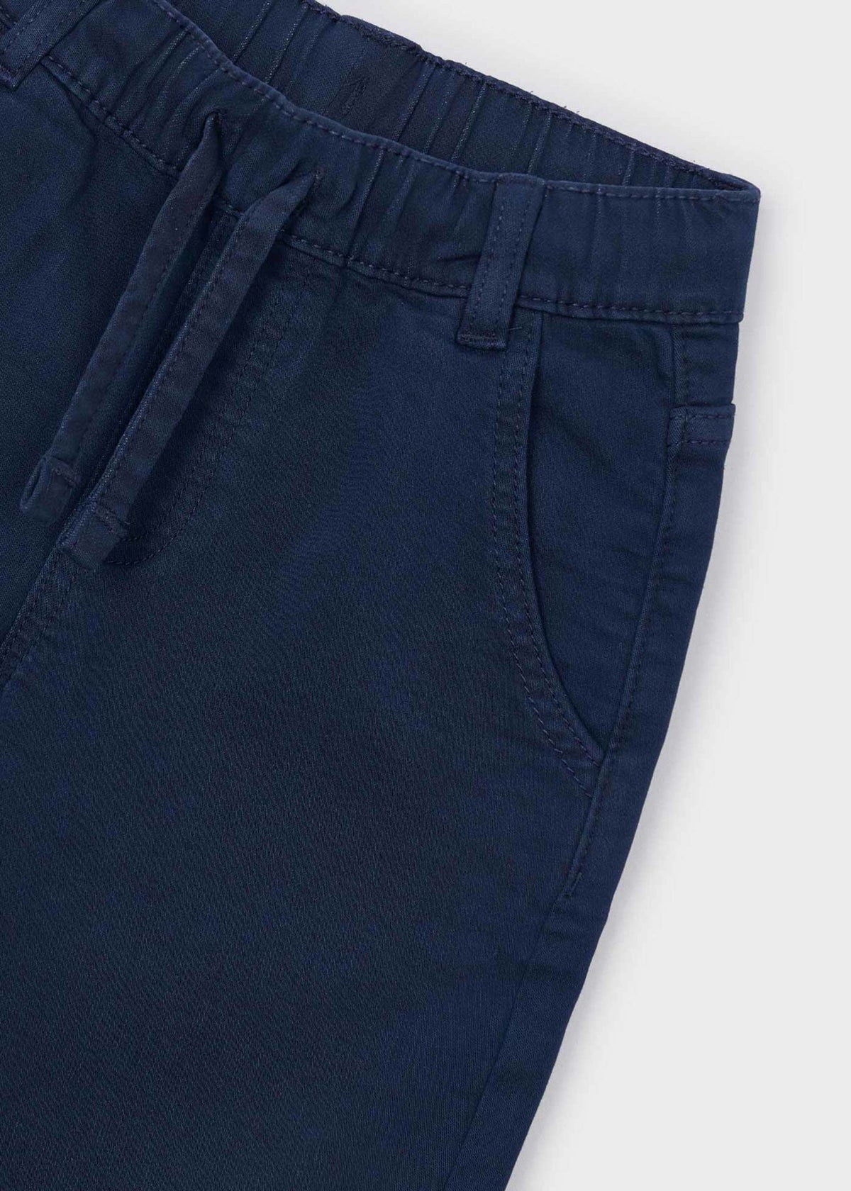 Close-up of the elastic waistband, drawstring and side pocket on the navy jogger pants