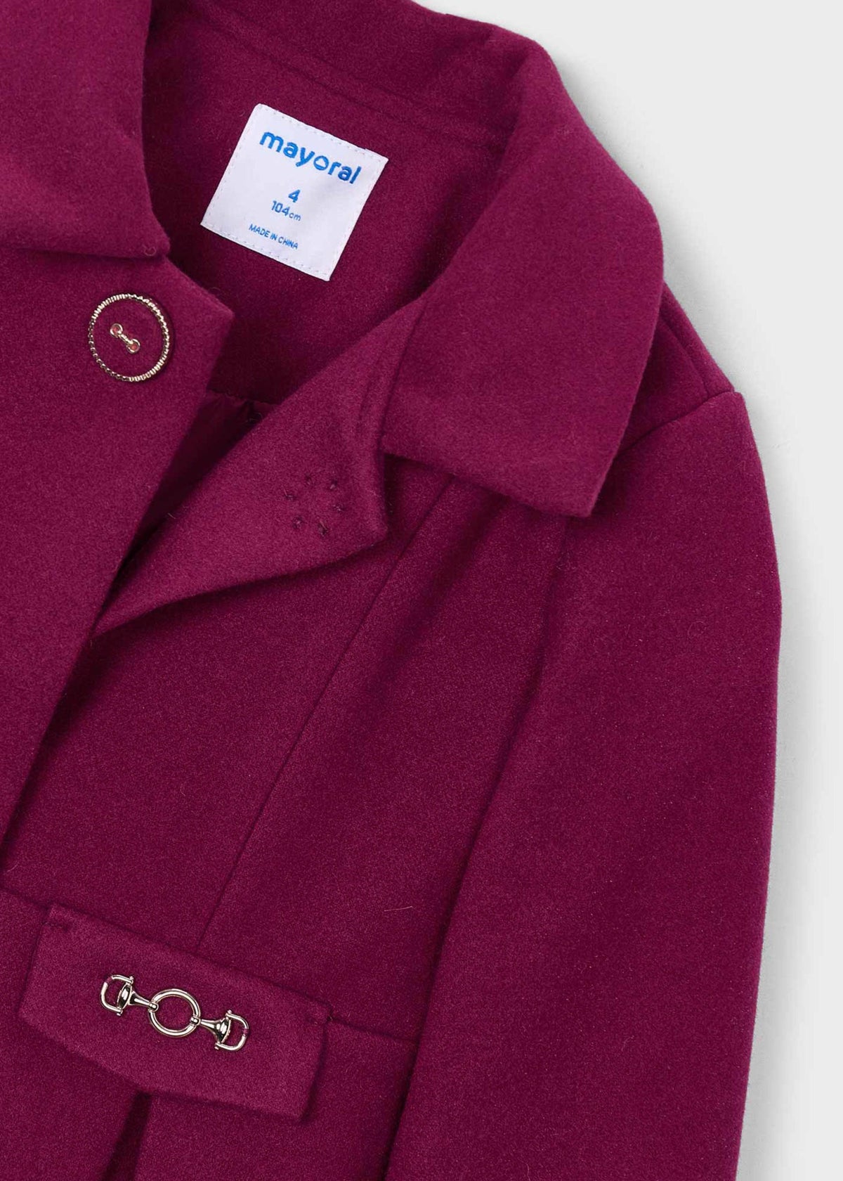 Close-up of the collar, button and buckle-style waist tab on the raspberry coat