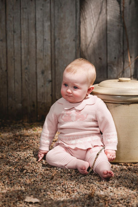 Baby girl in soft pink knit sweater with animal pattern and matching knit pants – cozy and stylish baby outfit from Jenni Kidz Canada.