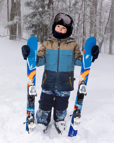 Child wearing Deux par Deux Blue Mountains Teknik snowsuit – front view on snow