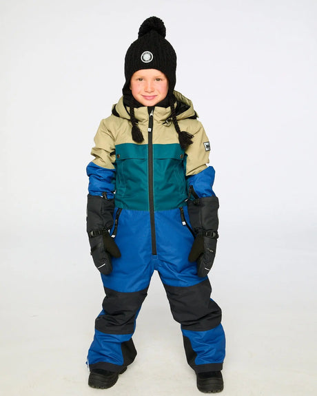 Child wearing Deux par Deux colorblocked navy one-piece Teknik snowsuit – front view on snow