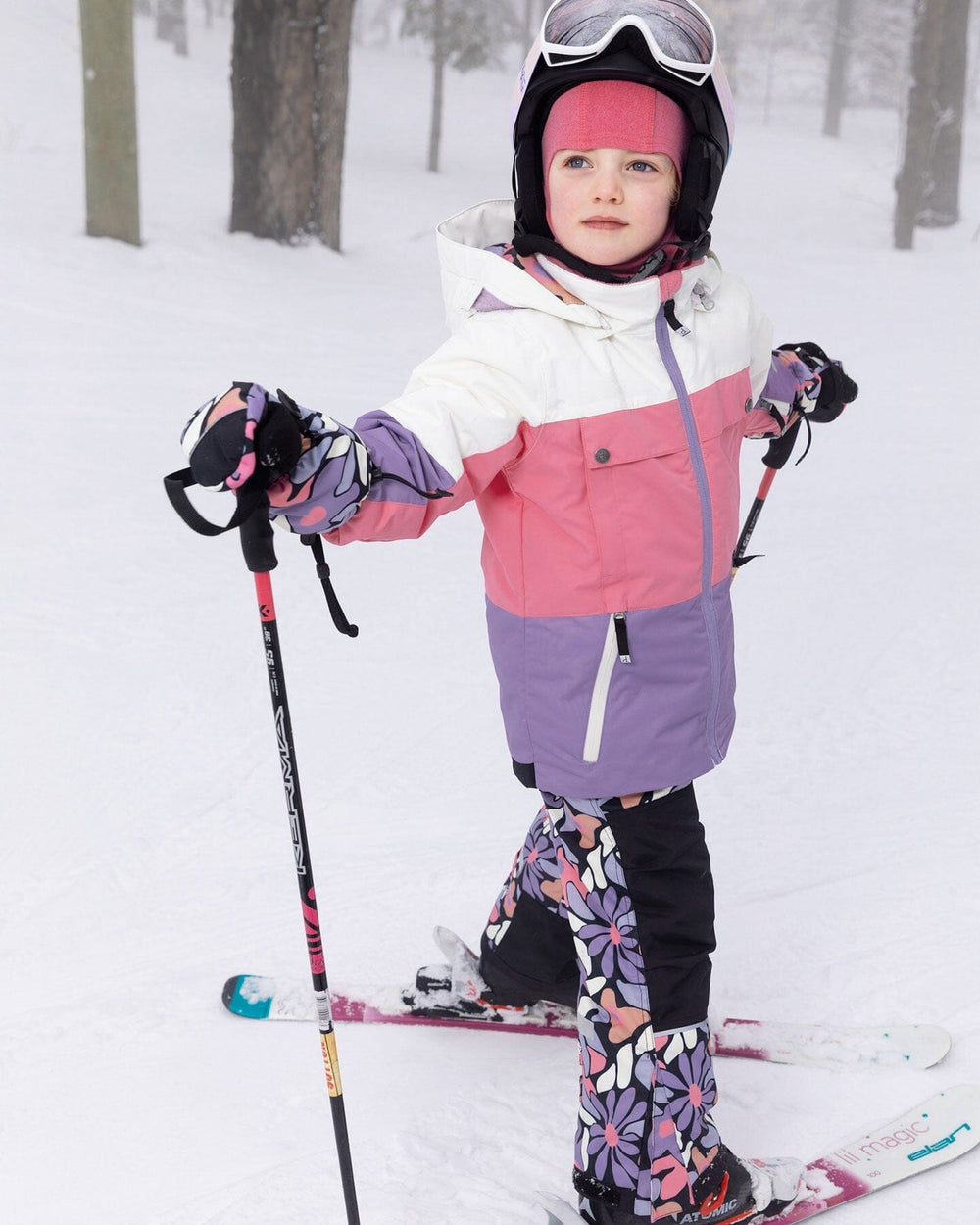 Child wearing black retro flower Teknik snowsuit set – front view on snow