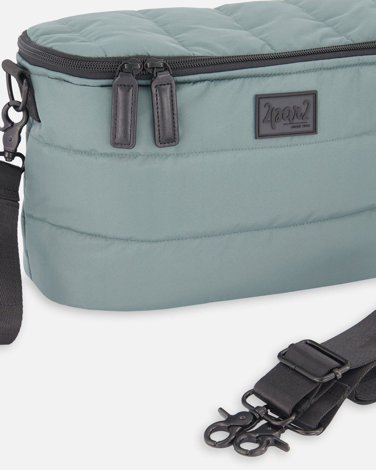 Close-up of the zipper pulls, black stroller clips and label on the sage green bag