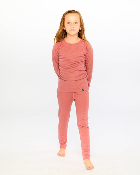 Girl standing barefoot in the dusty pink merino wool base layer set
