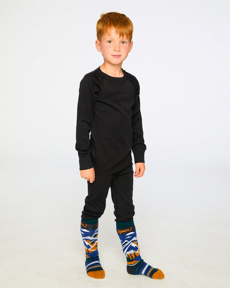 Boy wearing the black merino wool base layer set with patterned ski socks