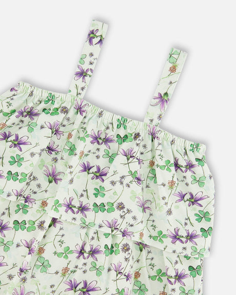 Close-up of the slim straps and the purple and green floral print on the tiered romper