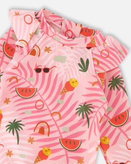 Close-up of the watermelon, palm tree and sunglasses print on the pink rashguard shoulder ruffle