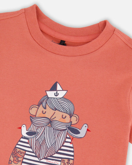 Close-up of the bearded sailor in a paper hat with two seagulls on the brick tee