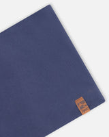Close-up of the navy jersey and leather-look label on the neck warmer