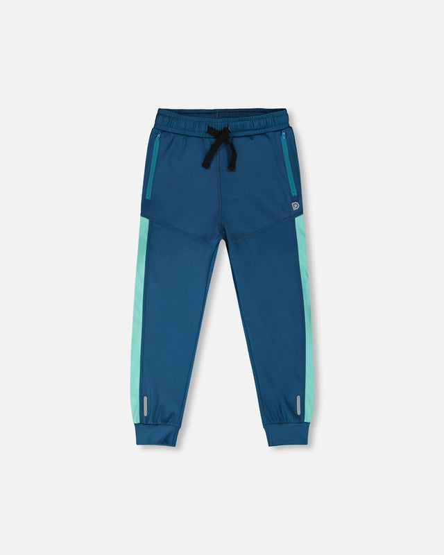 Deux par Deux teal athletic pants with aqua side panels and a black drawstring, front view