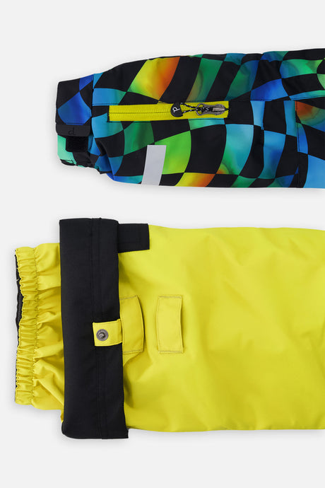Close-up of the checkerboard PLAY jacket ski-pass sleeve pocket and yellow pant hem