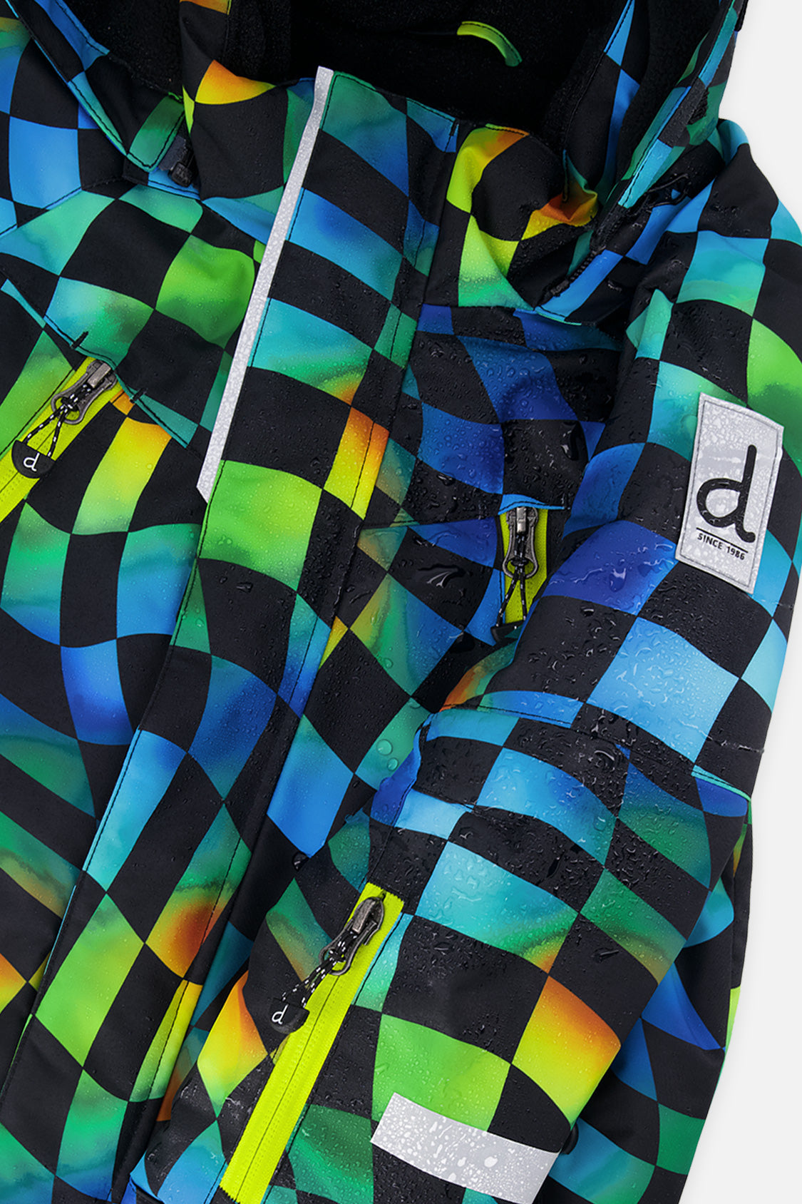 Close-up of the Deux par Deux checkerboard PLAY jacket shell, zipper and sleeve logo patch