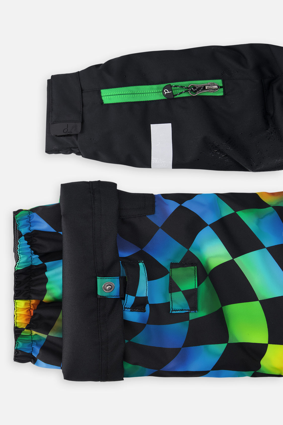 Close-up of the black sleeve ski-pass pocket and the adjustable checkerboard pant hem