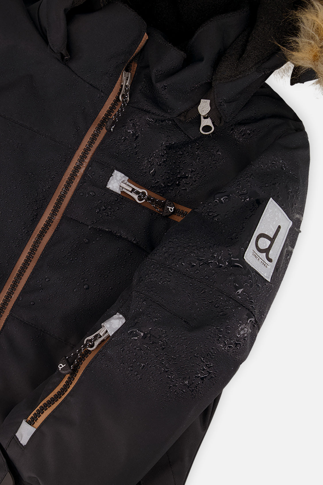Close-up of the black PLAY jacket front zipper and sleeve