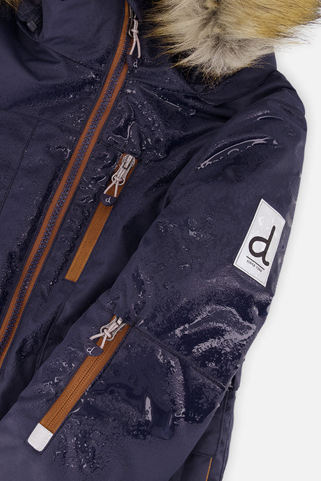 Close-up of the navy PLAY jacket shoulder with water beading on the shell and sleeve logo patch
