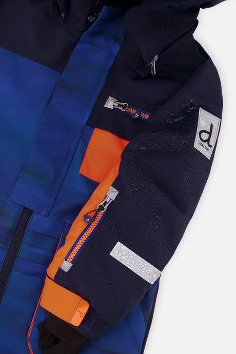 Close-up of the striped PLAY snowsuit sleeve with orange zipper pocket, reflective band and logo patch