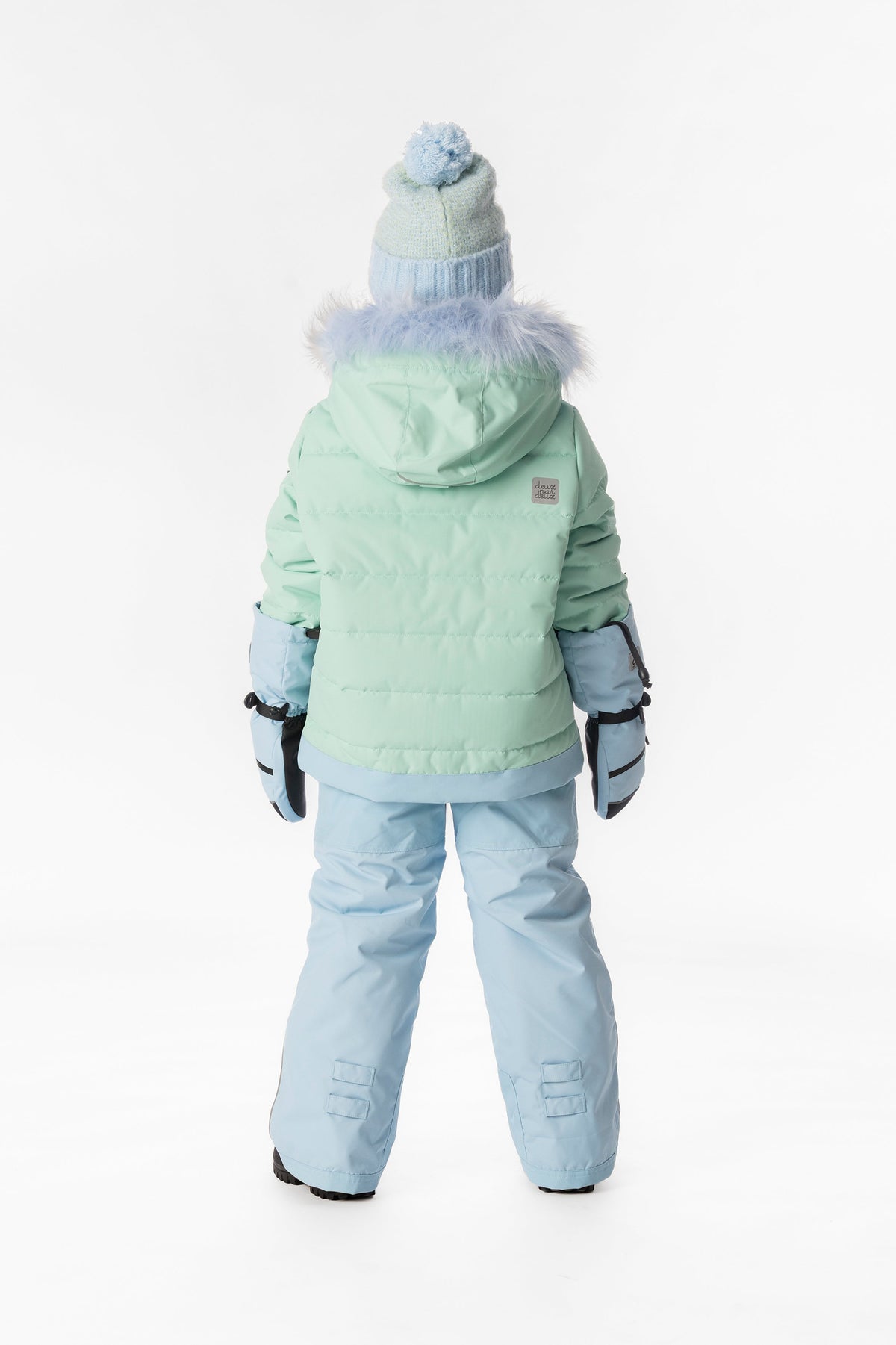 Girl in the mint green and light blue Deux par Deux PLAY snowsuit, back view