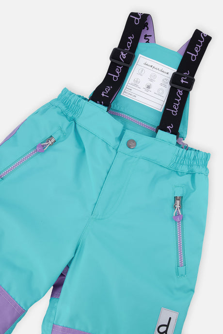 Close-up of the turquoise snow pants waist, suspenders and zippered pockets