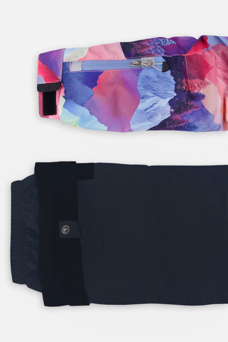 Close-up of the mountain-print sleeve ski-pass pocket and the adjustable black pant hem
