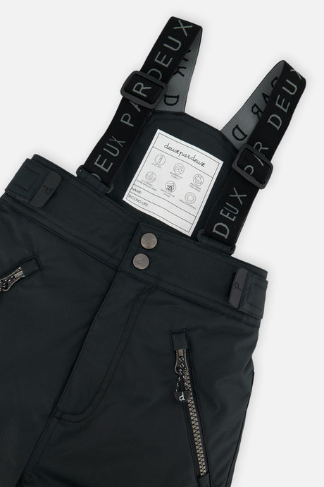 Close-up of the black Deux par Deux PLAY snow pants waist, zippered pockets and suspenders