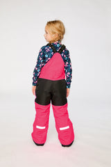 Back view of a child in the bright pink snow bib with reflective hem trims