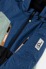 Water beading on the navy TEKNIK jacket beside the logo patch