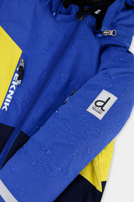 Water beading on the royal blue TEKNIK jacket sleeve beside the logo patch