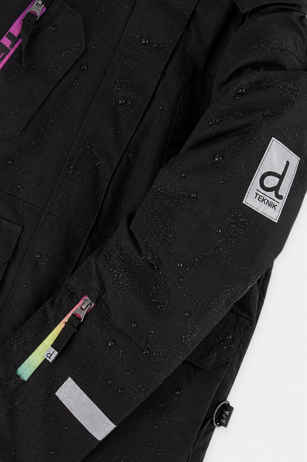 Deux par Deux girls' Teknik snowsuit, black jacket and pink-blue mountain print pants – logo badge close-up