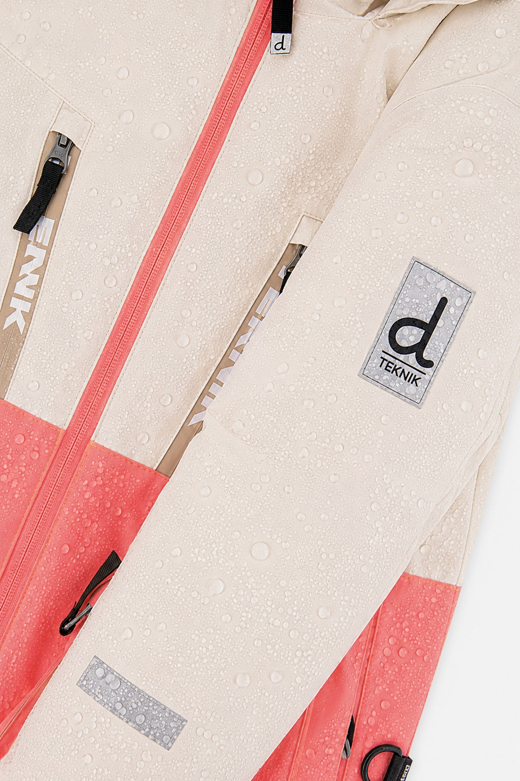 Water beading on the off-white and pink TEKNIK jacket shell beside the logo patch