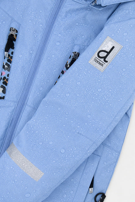 Water beading on the blue-violet TEKNIK jacket shell beside the logo patch
