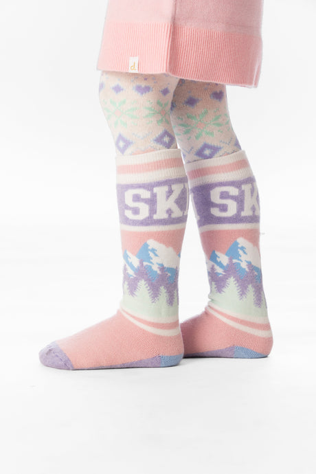 Child wearing light pink Deux par Deux SKI mountain socks over patterned tights, legs view