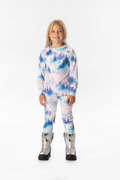 Child wearing the blue and pink mountain print two-piece thermal underwear set with silver boots, front view