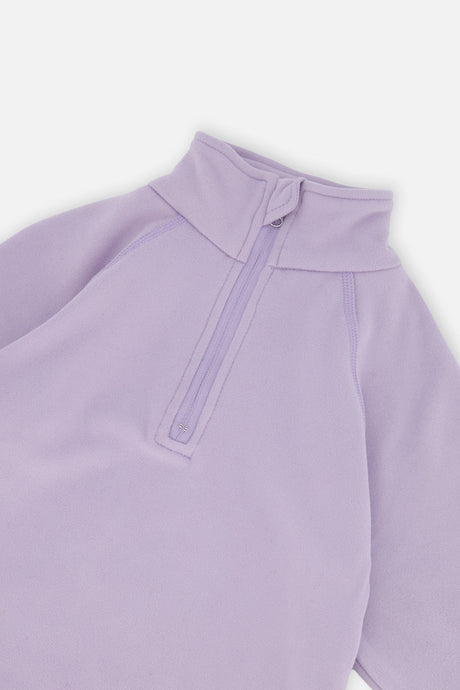 Close-up of the lavender half-zip mock neck and raglan sleeve seam